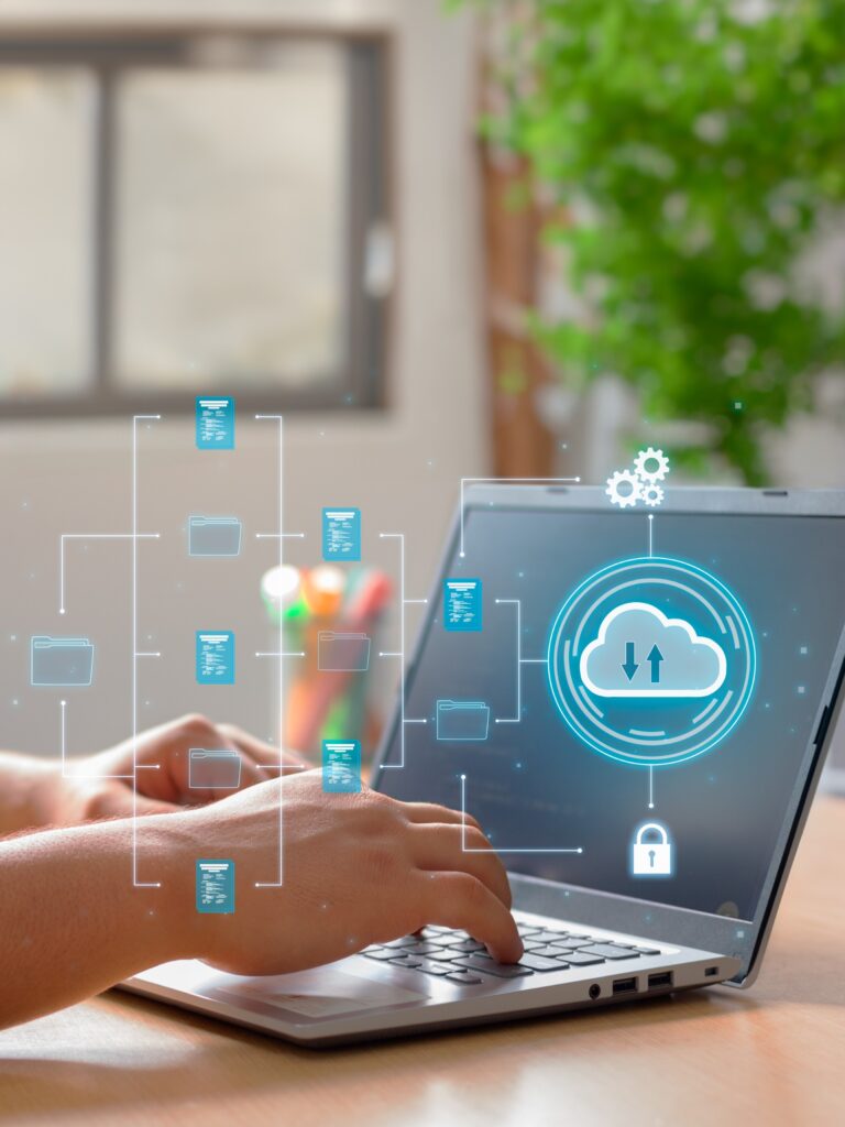 Person tippt am Laptop mit Symbolen für Cloud, Ordnerstruktur und Datensicherheit